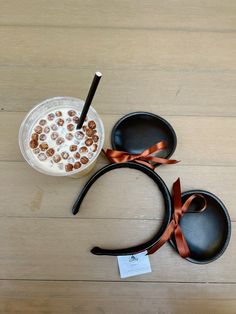 there is a bowl with cereal in it next to two spoons on the table