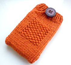 an orange knitted cell phone case with a button