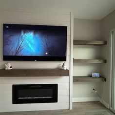 a flat screen tv mounted on the wall above a fireplace