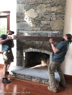 two men standing in front of a stone fireplace with their hands on the fire place