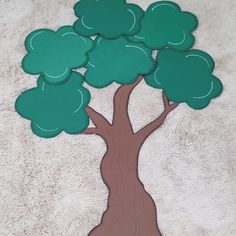 a paper cutout of a tree with green leaves on the top and brown trunk