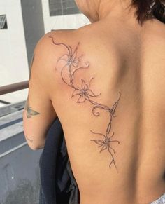 the back of a woman's shoulder with tattoos on her upper and lower arm