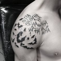 a black and white photo of a man's arm with bat tattoos on it