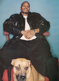 a man sitting in a chair next to a dog