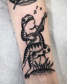 a black and white photo of a lizard with a guitar on it's arm