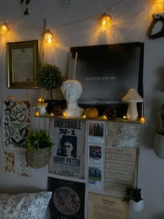 a room with posters, plants and lights on the wall next to a couch in front of it