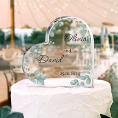 a heart shaped cake topper sitting on top of a white cake