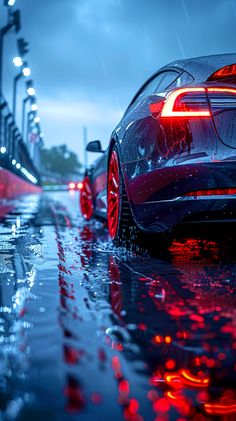 two cars parked in the rain on a city street at night with red and blue lights