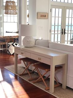 a living room with white furniture and wooden floors