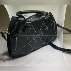 Spiderweb Purse Black Shoulder Bag Batwing Shaped Spider Bag Goth Emo Wicca 10” X 7” Black Widow Spiderweb Bag With Removable Shoulder Strap Single Compartment Bag Inside Is Dark Brown Cloth No Additional Zippers Or Pockets Inside Web Of Lies Handbag Vegan Leather Black Edgy Shoulder Bag For Halloween, Black Gothic Party Bags, Edgy Halloween Party Bags, Black Grunge Bag For Halloween, Punk Style Black Shoulder Bag For Evening, Punk Style Shoulder Bag For Halloween, Black Punk Evening Bags, Black Punk Style Evening Bags, Gothic Shoulder Bag For Halloween Party