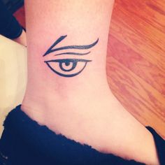 a woman's foot with an eye tattoo on the side of her left leg