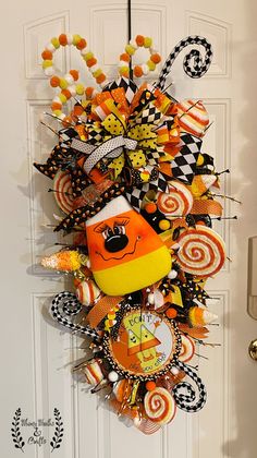 a halloween wreath hanging on the front door with candy and candies around it's edges