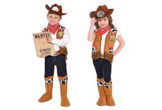 two children dressed in cowboy costumes holding signs and standing next to each other on white background