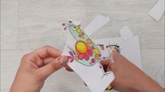 someone is cutting out some paper to make a giraffe ornament with scissors