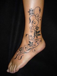 a woman's foot with flowers and vines on it