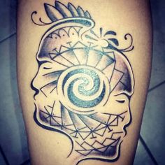 a tattoo on the leg of a person with a spiral design in the shape of a human head