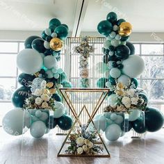 balloons and flowers are arranged in front of an arch