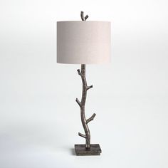 a lamp that is sitting on top of a wooden base with a white shade over it