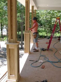 a young boy is standing on the porch with his hands in the air as he works on some wood