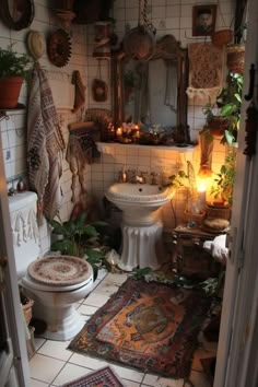 a white toilet sitting in a bathroom next to a sink and rugs on the floor