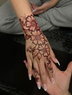 two hands with henna tattoos on them