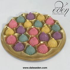 there are many small shells in the tray on the table, which is decorated with gold and pink