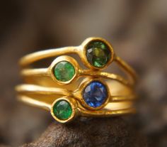 emerald gold ring//24k gold gem ring//green stone gold ring//gold multi stone ring//artisan gold ring //rustic gold ring//gold wide ring this is one ring made of four loops of wire , with green and blue gem stone. the 4 ring wire is 1.1 mm thick and its made with 22k gold wire (92%) the bezel setting is 24k gold giving the ring an outstanding color . You can have the rings separately too. the stones are: two 2.75 green emerald one 4.5 mm blue Kyanite one 4.5 mm green tourmaline the gold bezel se Unique Gold Emerald Ring Birthstone, Green Stone Gold Ring, Stone Gold Ring, Emerald Gold Ring, Ring Green Stone, Rough Diamond Ring, Handmade Fine Jewelry, Ringe Gold, Wide Ring