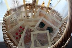 a wicker basket filled with pictures sitting on top of a table next to a window