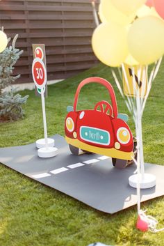 a toy car with balloons in the back ground and a sign that says 30 on it