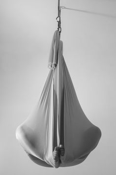 a white hammock hanging from a hook on a wall in black and white