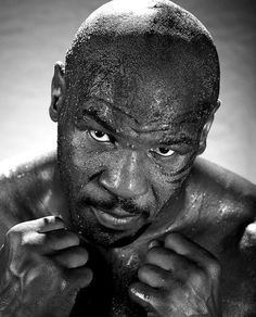 a black and white photo of a man with mud on his face