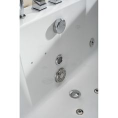 a white bath tub with chrome faucets and hand shower heads on the side