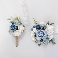 two bridal bouquets with blue and white flowers are on the wall next to each other