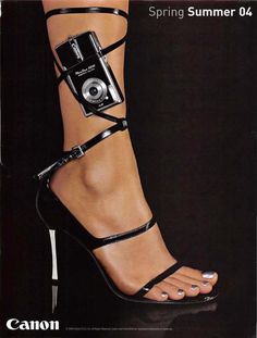 a woman's legs wearing high heel sandals with camera strapped to the ankle and strap around her ankles