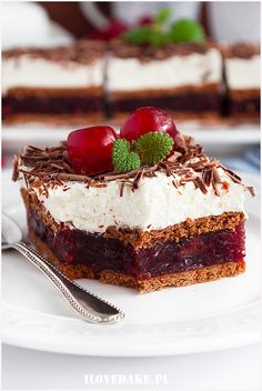 there is a piece of cake on the plate with cherries and chocolate shavings