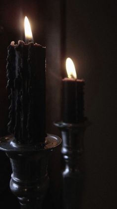 two lit candles sitting on top of a table