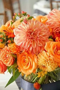 a vase filled with orange flowers on top of a table