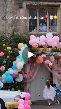 a girl is walking in front of a building with balloons and streamers all around her