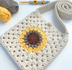 a crocheted granny bag sitting on top of a table next to some yarn