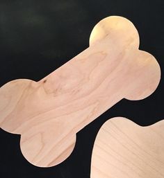 two wooden skateboards laying next to each other on top of a black surface,