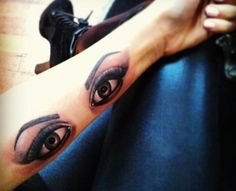 a woman's leg with an eye tattoo on it