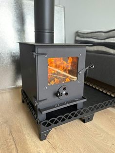 a wood burning stove sitting on top of a wooden floor