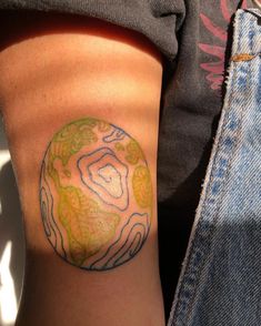 a person with a tattoo on their arm that has an image of a planet in it