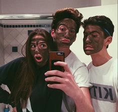 three people are taking a selfie in the bathroom with their faces painted like zombies