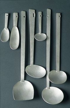 spoons and spatulas are arranged on a gray surface, one is empty