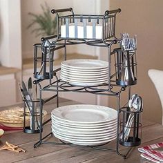 a stack of plates sitting on top of a wooden table next to a knife and fork holder