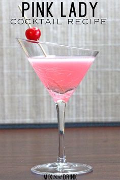 a pink drink with a cherry on the top in a martini glass sitting on a table