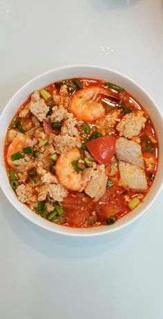 a white bowl filled with soup and shrimp