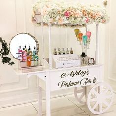 an ice cream cart with flowers on the top and some bottles in front of it