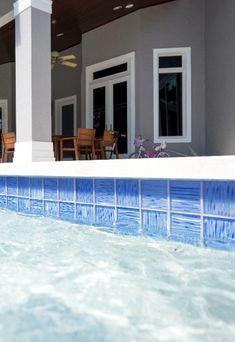 an empty swimming pool in front of a house